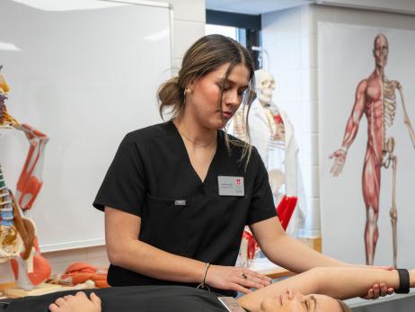 Students gather for a demonstration during an athletic training class.